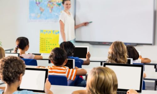 Schoolchildren using tablets against teacher