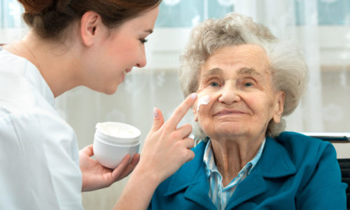 Elderly woman is assisted by nurse at home